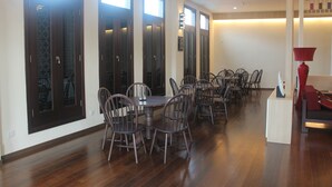 A spacious dining area with a long table and multiple chairs, large windows with dark wooden frames, and a ceiling fan. - Fomecs Boutique Hotel, Jonker Street (Malacca City)