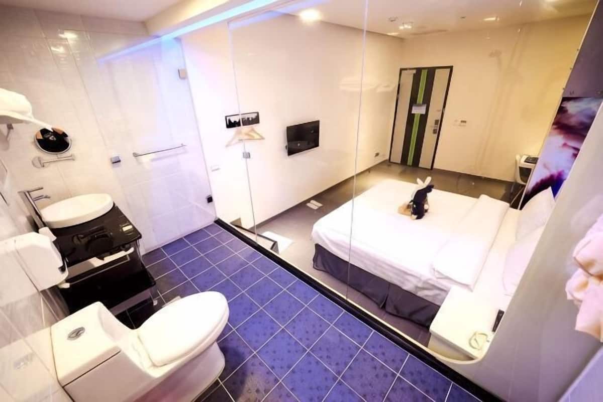 A modern bathroom with a toilet, sink, and mirror.