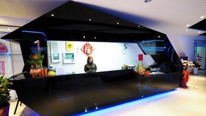 A modern reception desk with a black surface and blue LED lighting.