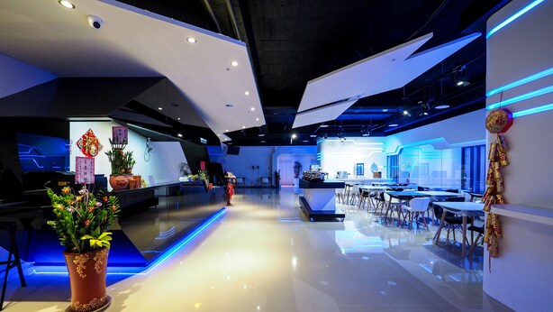 A modern hotel lobby with a polished floor, a reception desk, and a seating area.