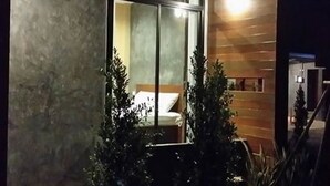 A modern hotel room with a large window, a bed, and a wooden wall. - The Infinite Resort Nakhon Sawan (Nakhon Sawan)