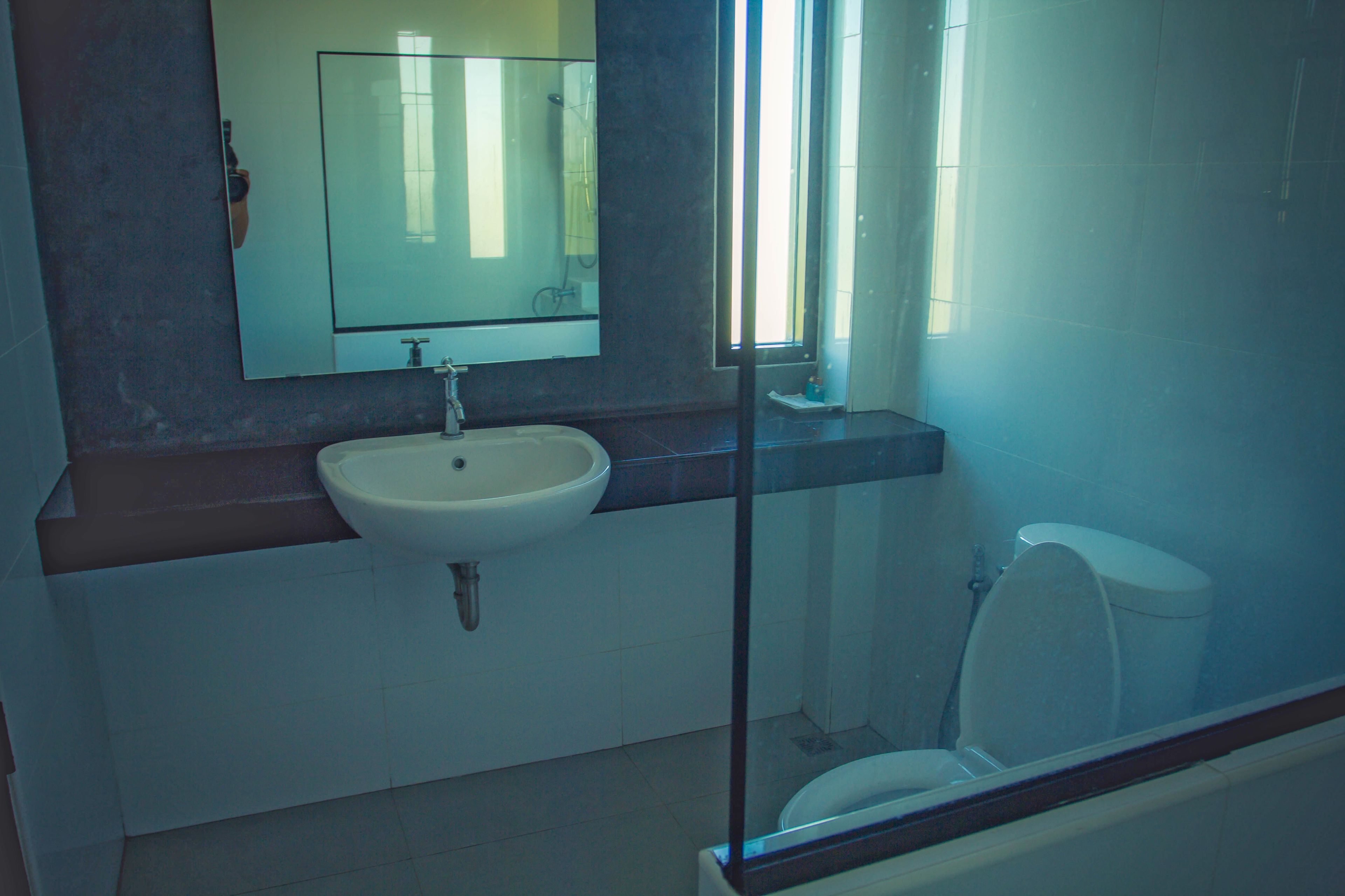 A bathroom with a sink, mirror, and toilet.