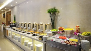 Un buffet proposant divers plats et une pancarte indiquant « HÔTEL ARISTO ».