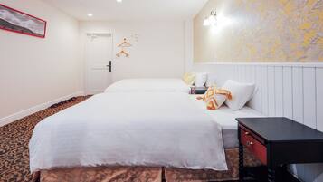 Une chambre d’hôtel avec deux lits, un petit bureau et une moquette à motifs.