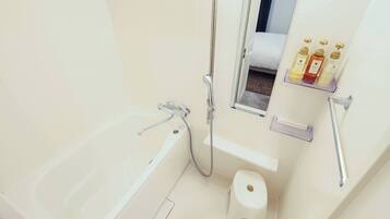 A modern bathroom with a bathtub, a shower, a toilet, and a shelf with toiletries.
