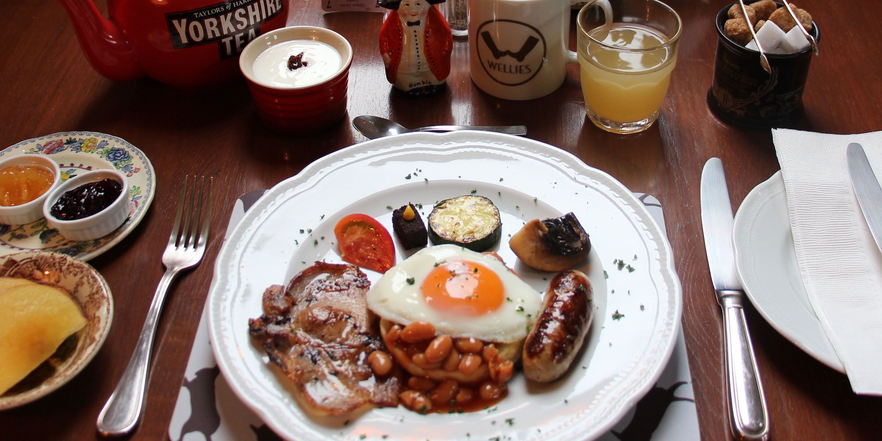 Ein Frühstücksteller mit Eiern, Bohnen, Würstchen und Toastbrot.
