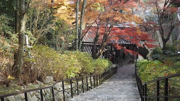 Una escalera de piedra que conduce a una construcción tradicional japonesa con techo de tejas.
