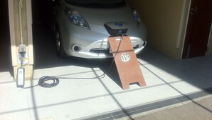 A car parked inside a building with a charging station and a sign on the ground. - HOTEL WOO - Adults Only (Yamatotakada)