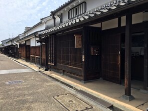 A row of traditional Japanese buildings with wooden doors and tiled roofs. - HOTEL WOO - Adults Only (Yamatotakada)