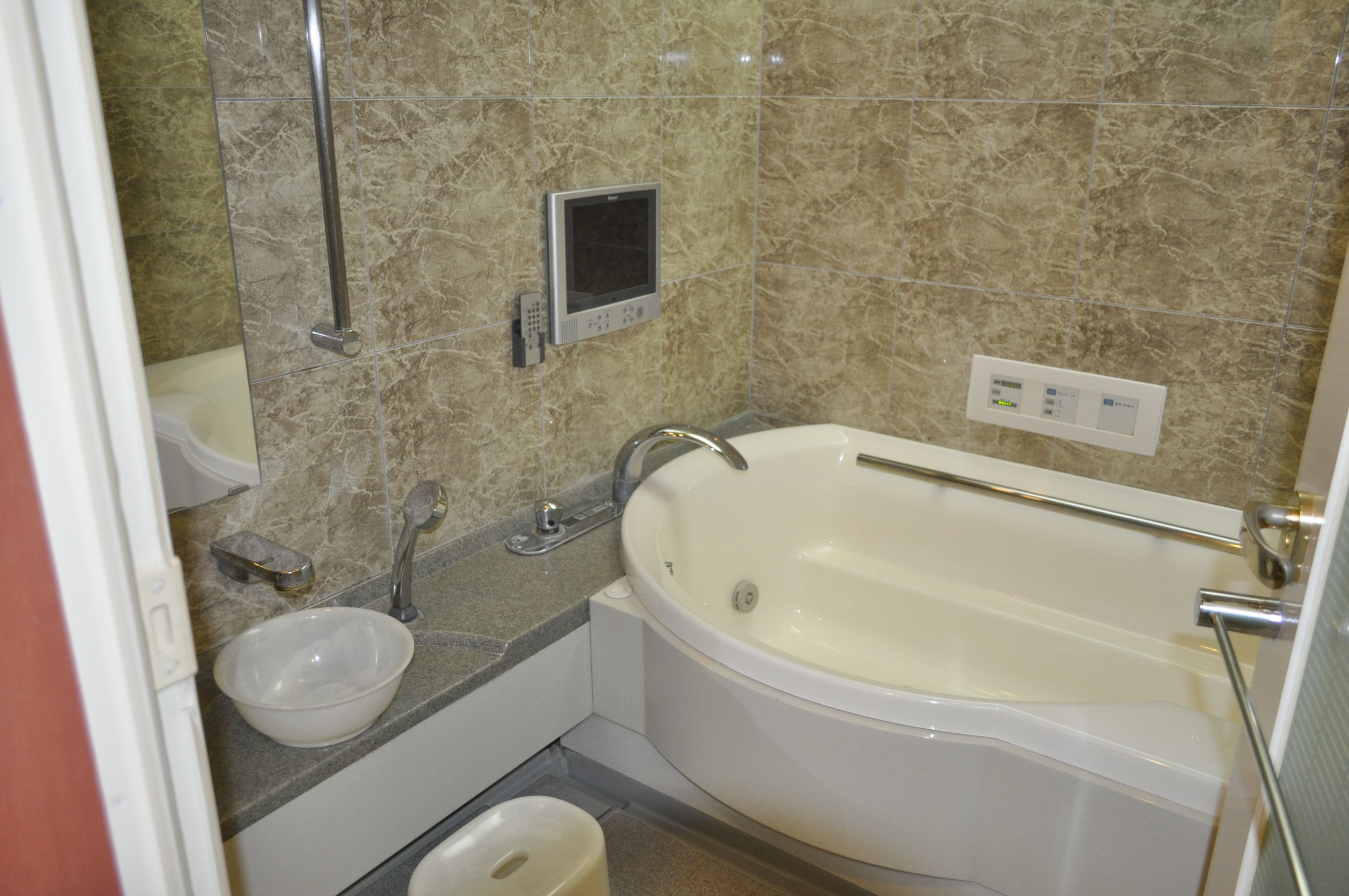 Un baño con bañera, lavabo, inodoro y ducha de mano.