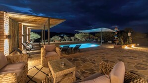 An outdoor pool area with lounge chairs and a stone patio. - Windhoek Game Camp (Windhoek)
