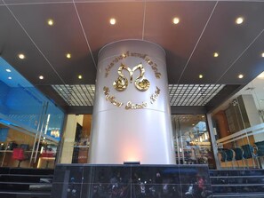 A hotel entrance with a large pillar featuring the hotel's name and logo.