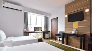 A hotel room with two beds, a desk, a chair, a TV, and a window with curtains. - Mayflower Grande Hotel Hat Yai (Hat Yai)