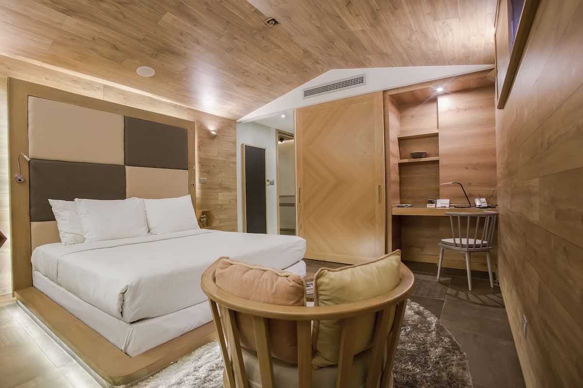 A bedroom with a bed, a desk, and a chair.