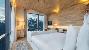 A modern bedroom with a large bed, a desk, and a TV.
