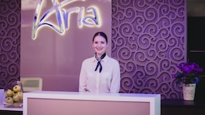 A reception desk with a neon sign reading "Atria" and a decorative wall with a swirl pattern. - Aria Hotel Chisinau (Chisinau)