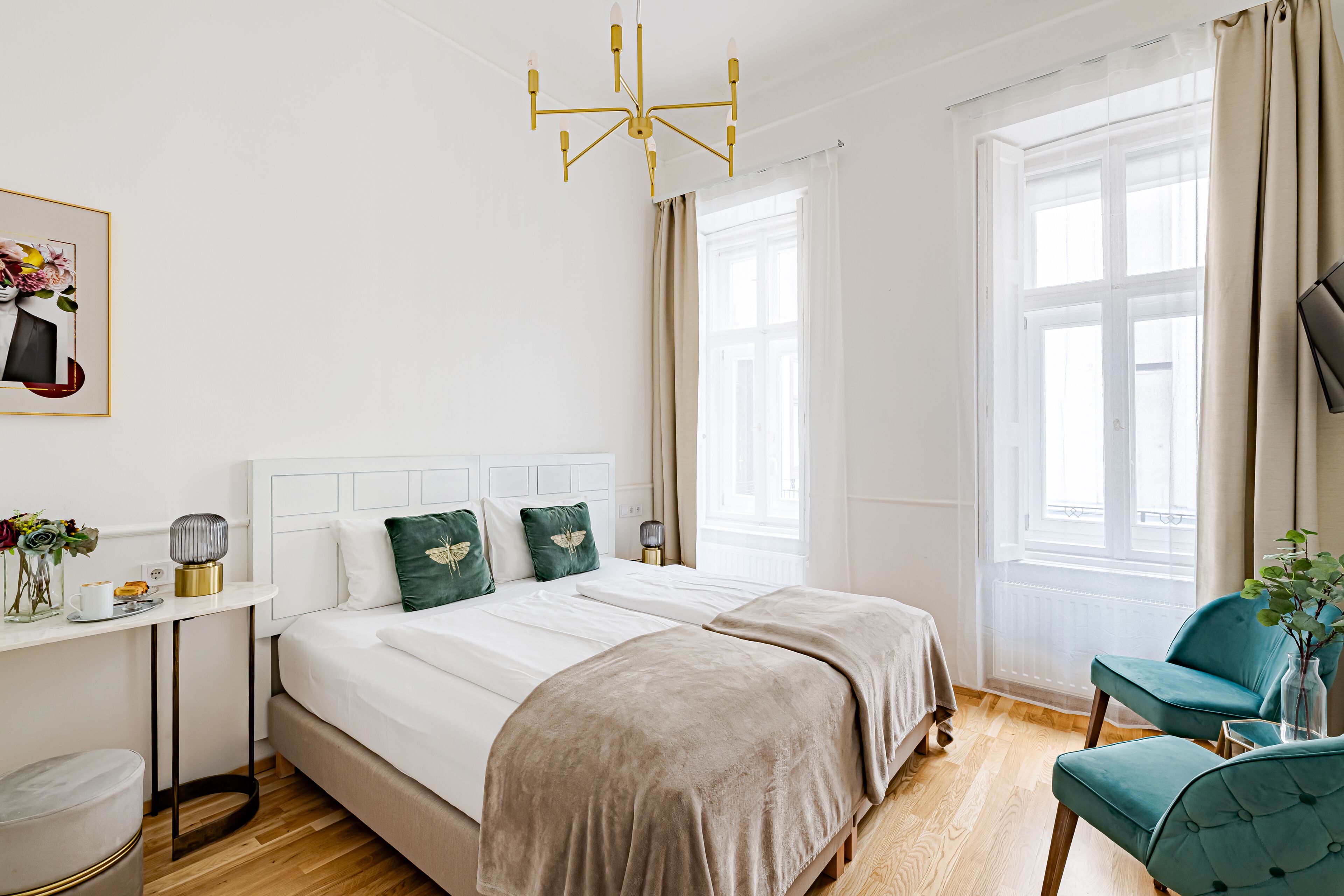 A bedroom with a large bed, bedside tables, a chair, and a window with curtains.
