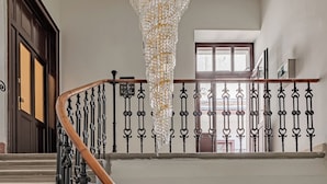 Un magnifique escalier orné de balustrades noires et d’une main courante en bois, menant à un balcon du deuxième étage offrant une vue imprenable.