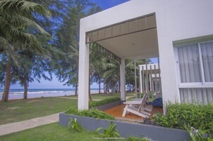 Un edificio moderno con un patio cubierto, piscina y vistas a la playa.