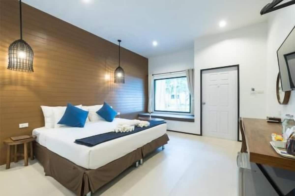 A bedroom with a bed, bedside tables, a window, and a door.
