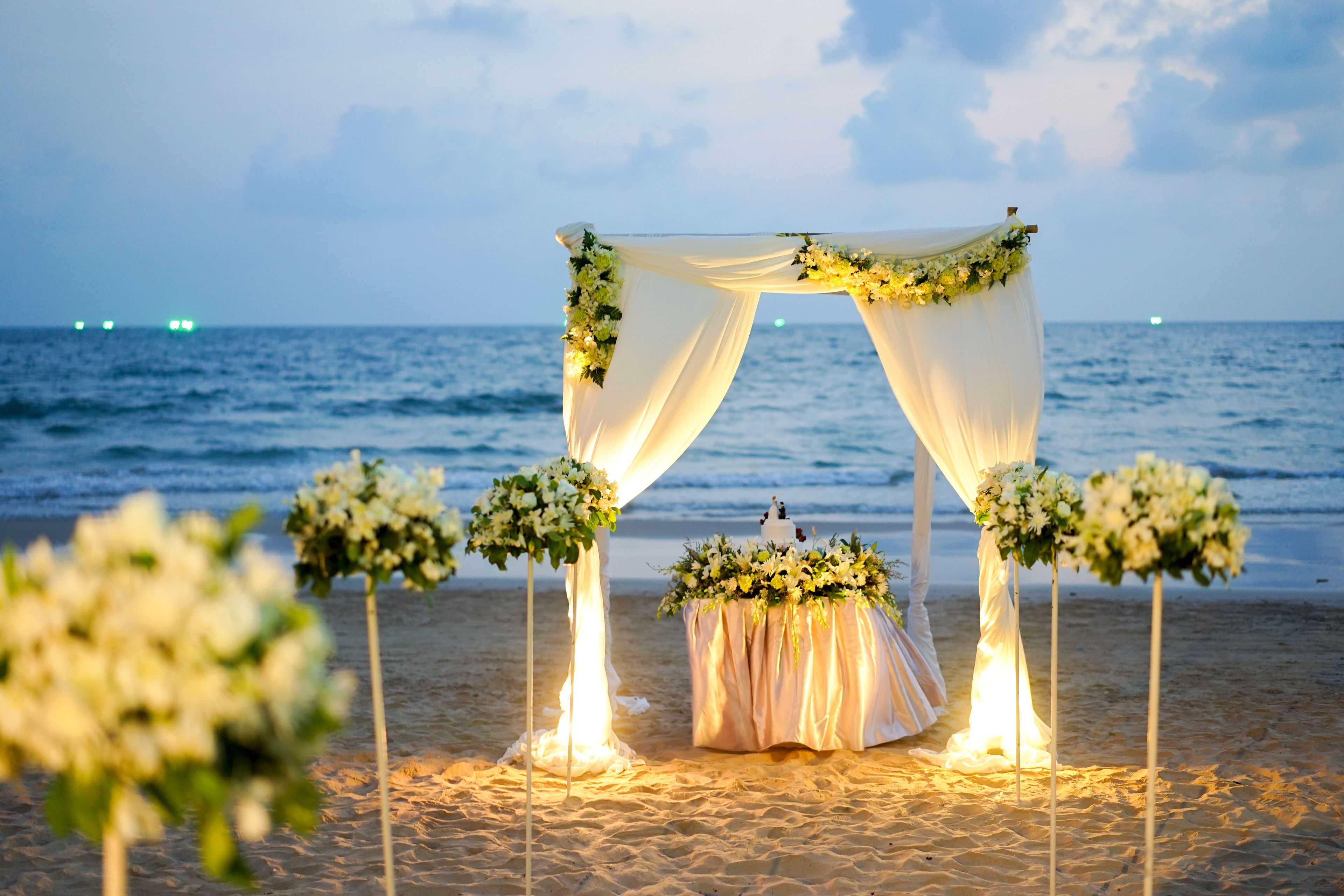 A beach wedding setup with a canopy and floral arrangements.