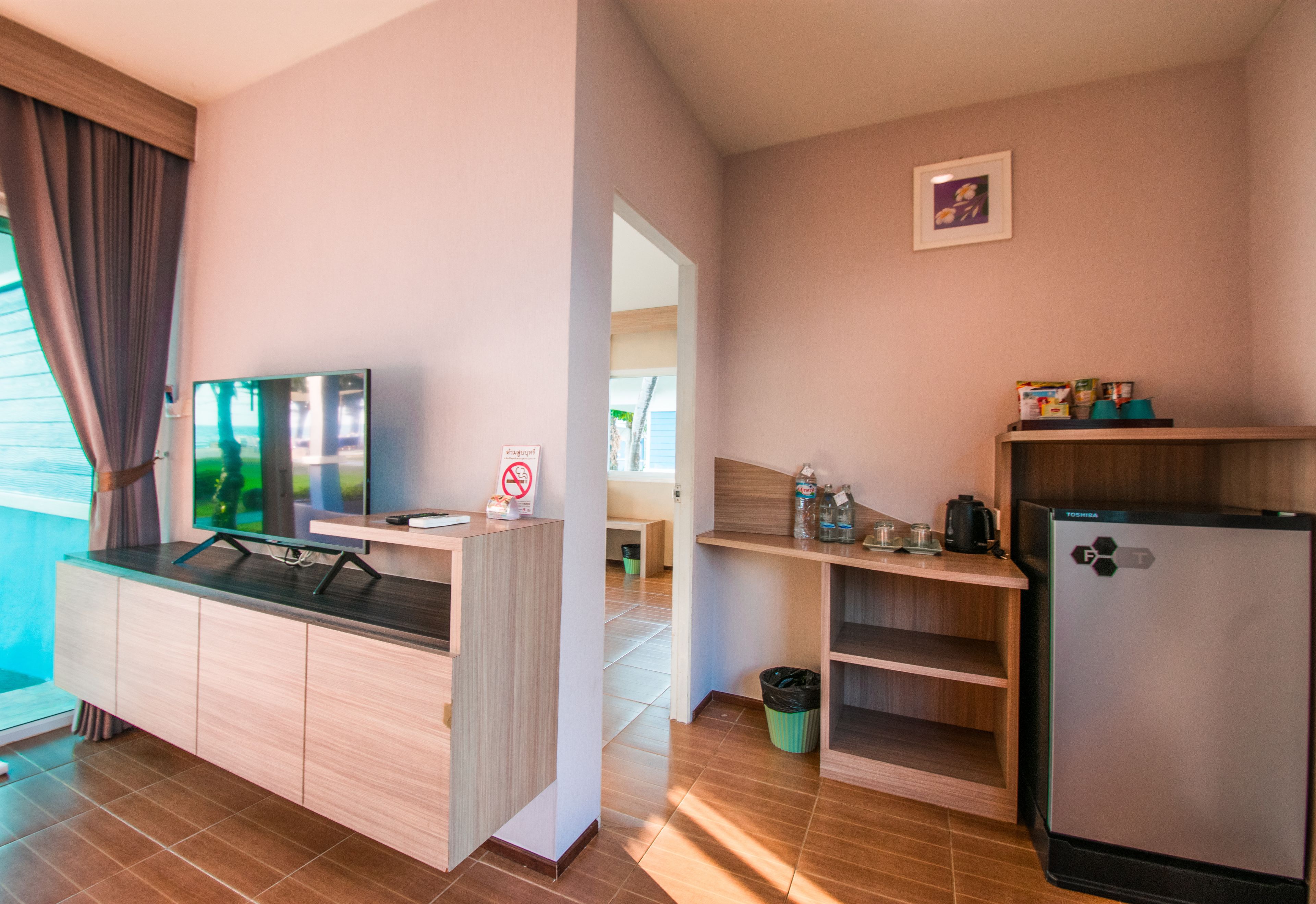 A compact kitchenette with a refrigerator, a microwave, and a sink.