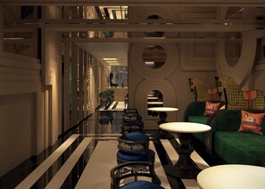 A modern interior with a reflective floor, green seating area, and a long corridor with a green chair and tables. - Hôtel Le Joyau Bleu Hanoï (Hanoi)