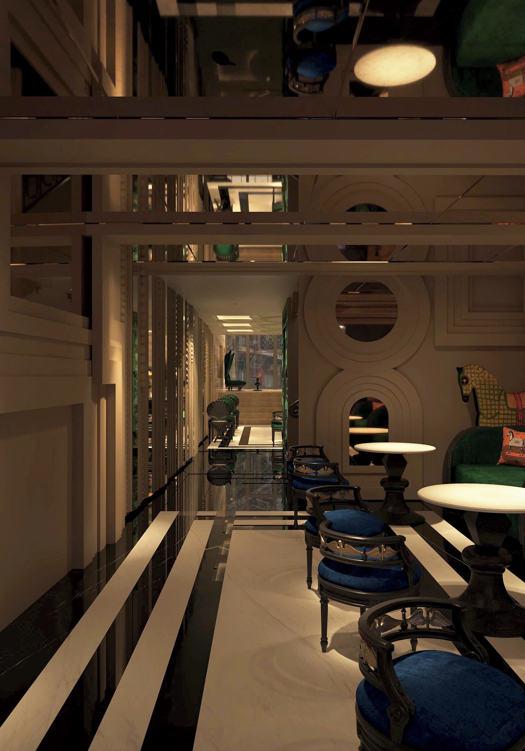 A corridor with a reflective floor, a seating area with blue upholstered chairs, and a table with a white top.