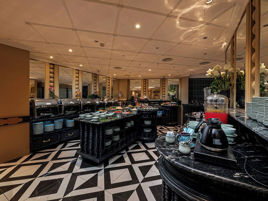 A buffet area with multiple serving stations, a coffee machine, and a variety of dishes.