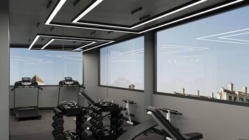 A modern gym with treadmills, dumbbells, and weight machines, large windows, and a view of the cityscape.