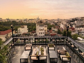 A rooftop terrace with outdoor seating and a cityscape view. - Hôtel Le Joyau Bleu Hanoï (Hanoi)
