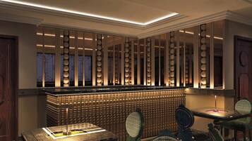 A bar area with a high counter, bar stools, and a patterned floor.