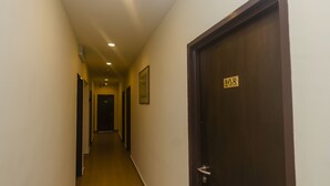 A hallway with a wooden door marked with the number 208.