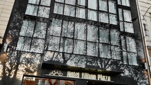 A modern hotel with a black facade and large windows.