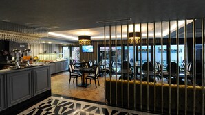 A modern dining area with a bar, seating, and a view of the cityscape. - Le Petit Palace Hotel (Istanbul)