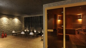 A spa area with stone walls, wooden benches, and a glass door leading to a sauna room. - Le Petit Palace Hotel (Istanbul)