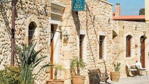 A stone building with a sign reading "Hotel Casa di Venezia" and outdoor seating. - Casa Di Veneto (Hersonissos)