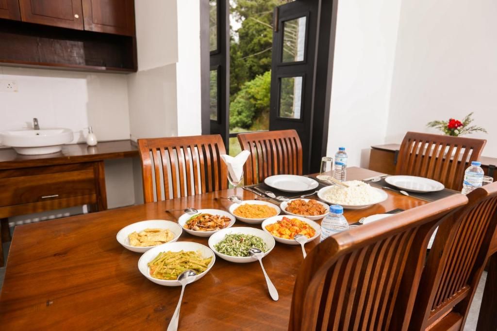A dining table set with various dishes, a water bottle, and a glass.