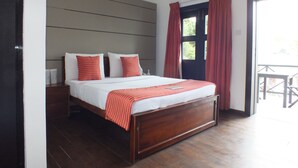 Een slaapkamer met een houten bed, witte beddengoed en rode gordijnen.