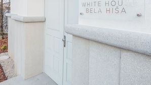 Una entrada de edificio con un letrero que dice "WHITE HOUSE BELA HIŞA".