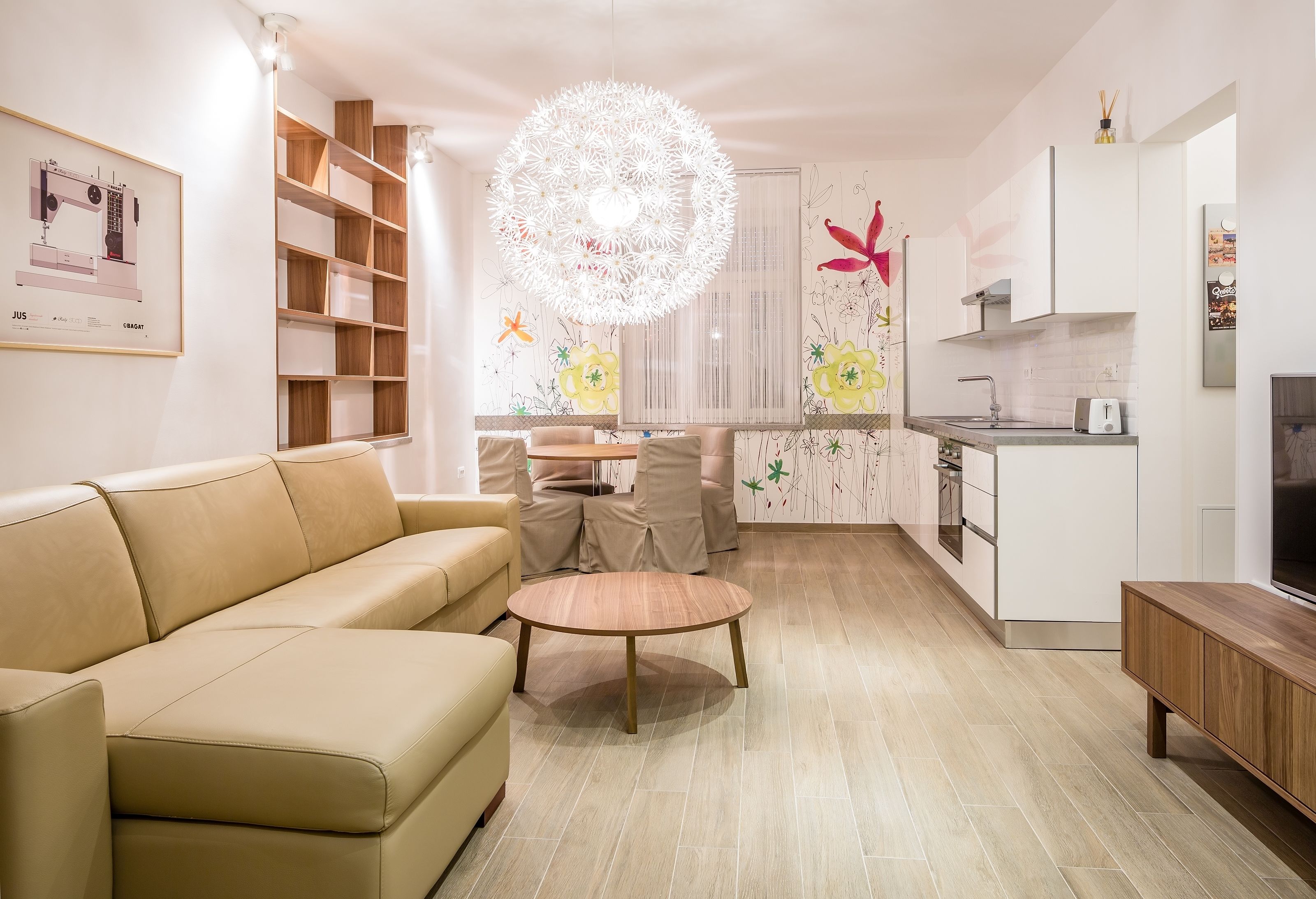 Una sala de estar moderna con un sofá color beige, una mesa de centro de madera y un comedor con una mesa y sillas blancas.