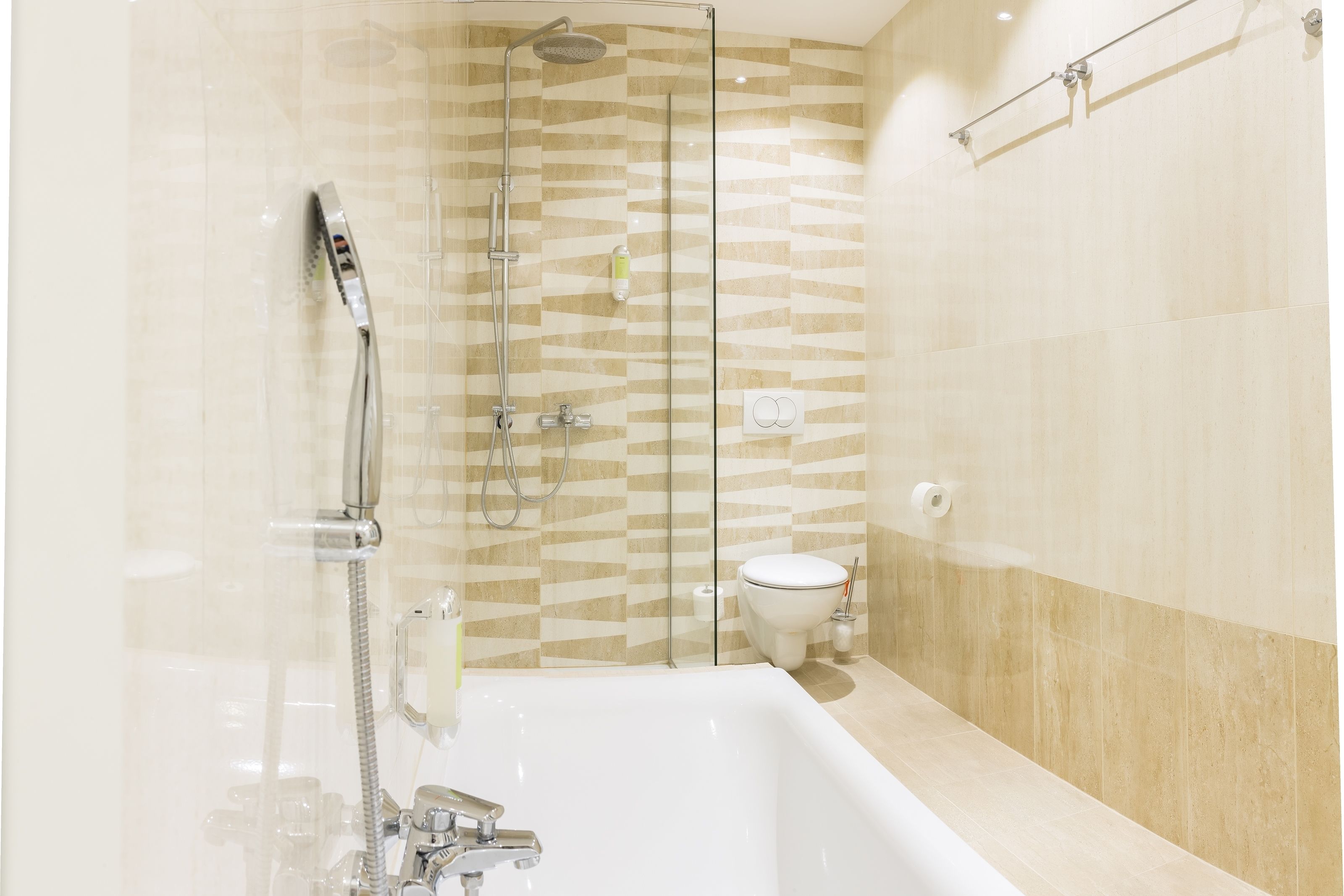 A modern bathroom with a glass-enclosed shower, a standalone bathtub, and a toilet.