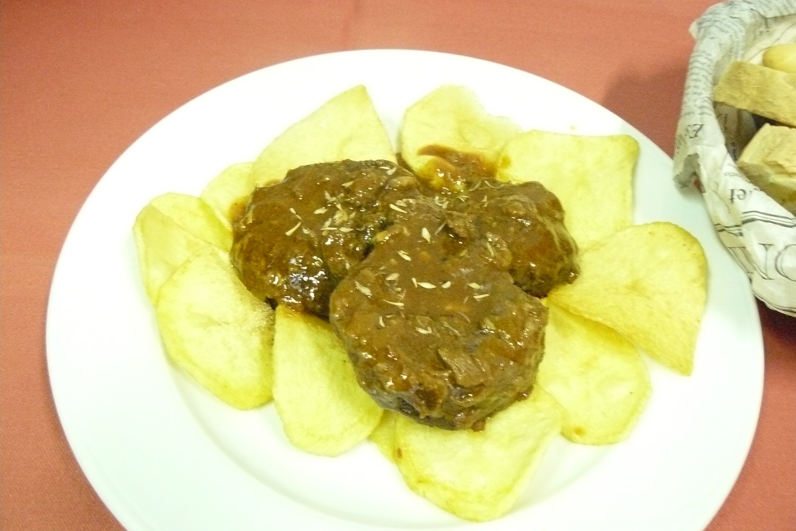 Un plato con dos hamburguesas de carne y patatas fritas.