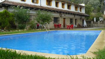 Een buitenzwembad, parasols voor strand/zwembad