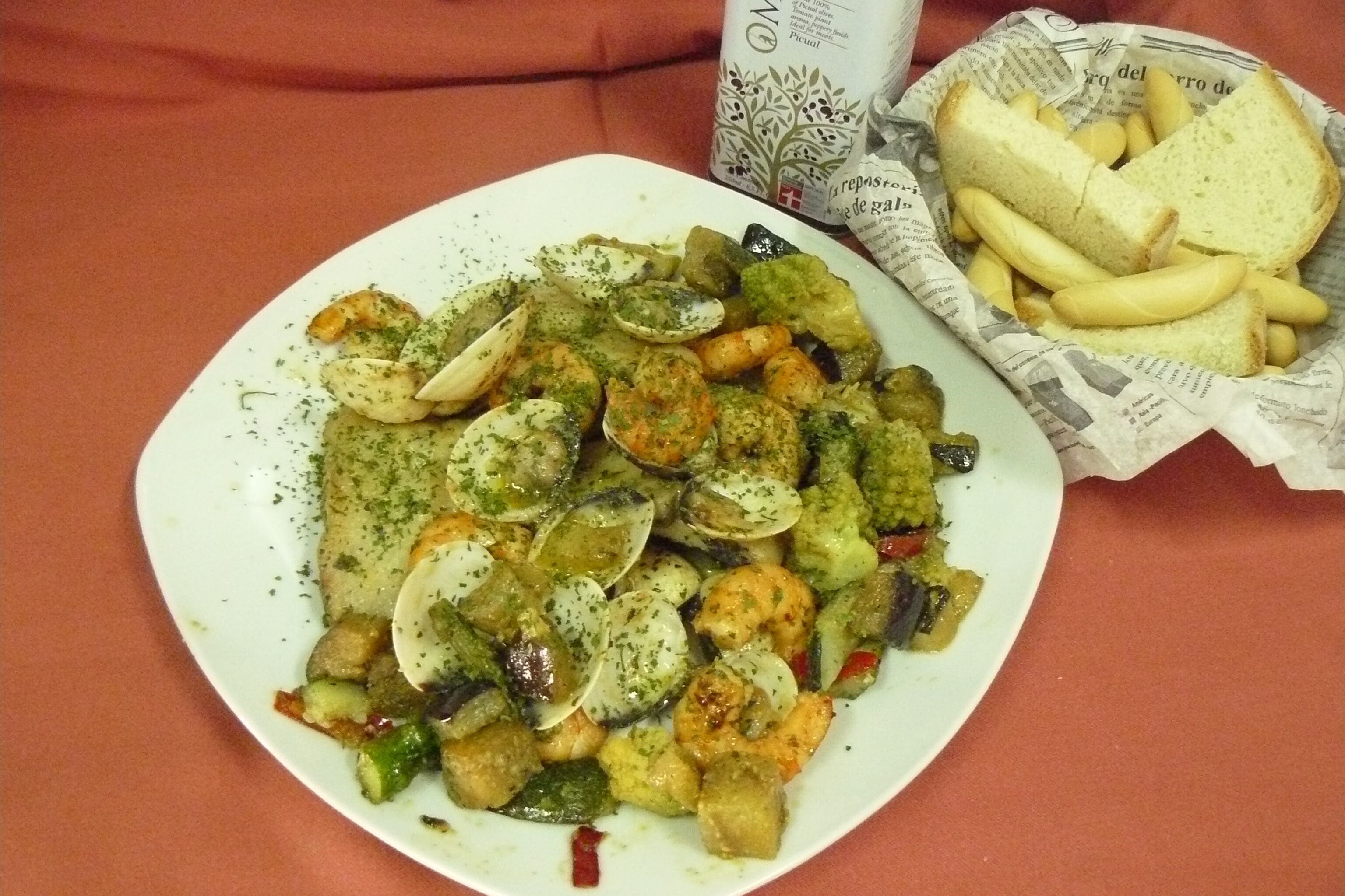 A plate of seafood with bread and fries.