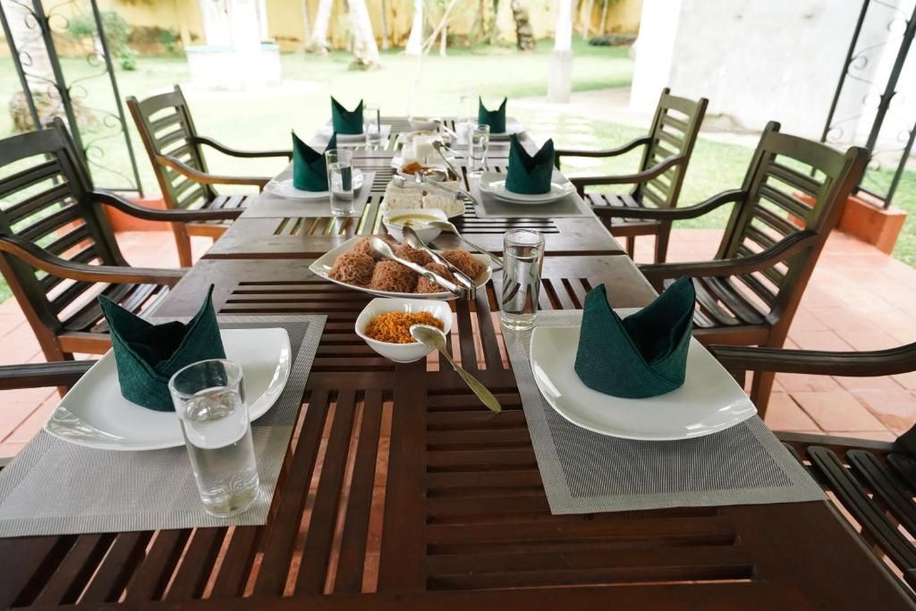 A dining table set for four with plates, cutlery, and napkins.