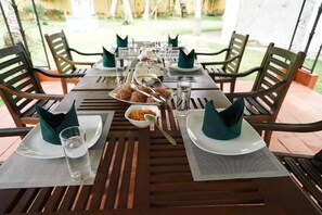 A dining table set for four with plates, cutlery, and napkins. - Gedara Resort (Wadduwa)