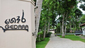 Une enseigne portant le numéro 6036 et le mot « GEDARA » est fixée à un bâtiment.