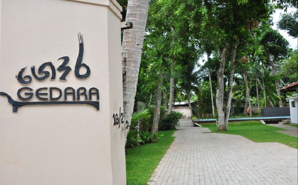 Un letrero con el número 6036 y la palabra 'GEDARA' en un edificio.