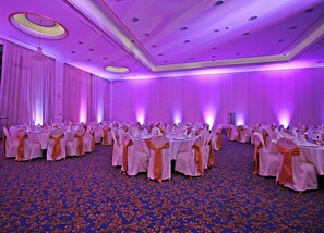 A banquet hall with round tables, chairs, and a blue patterned carpet. - Aleksander Palace (Skopje)